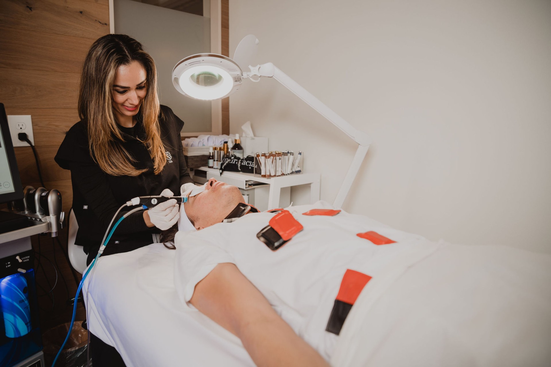 A Lua therapist performing a HydraFacial with a treatment handpiece